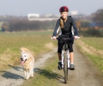 Junge Frau mit Hund beim Radfahren